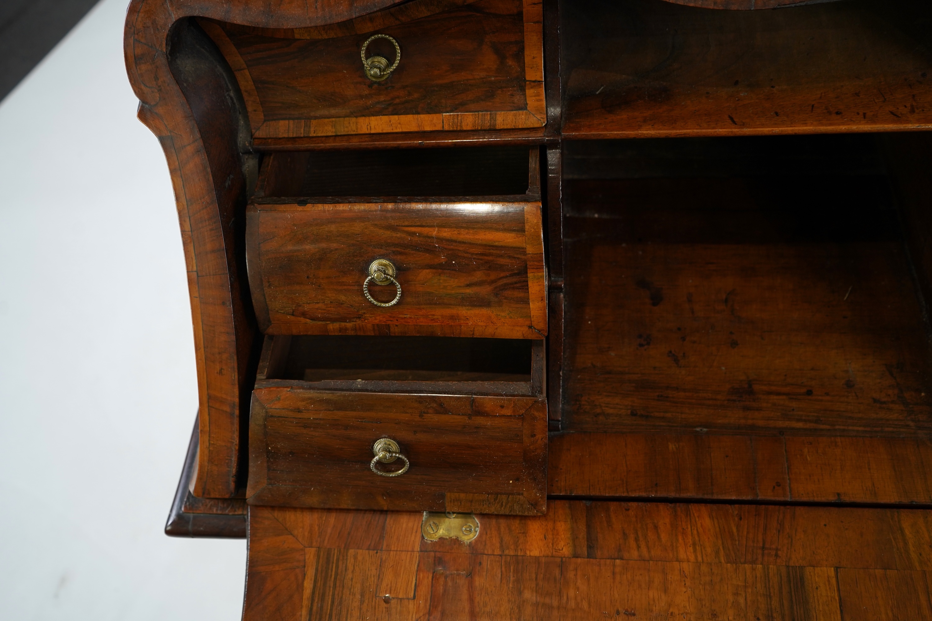 A mid 18th century North Italian or Maltese walnut and olive wood gilt metal mounted serpentine bureau cabinet